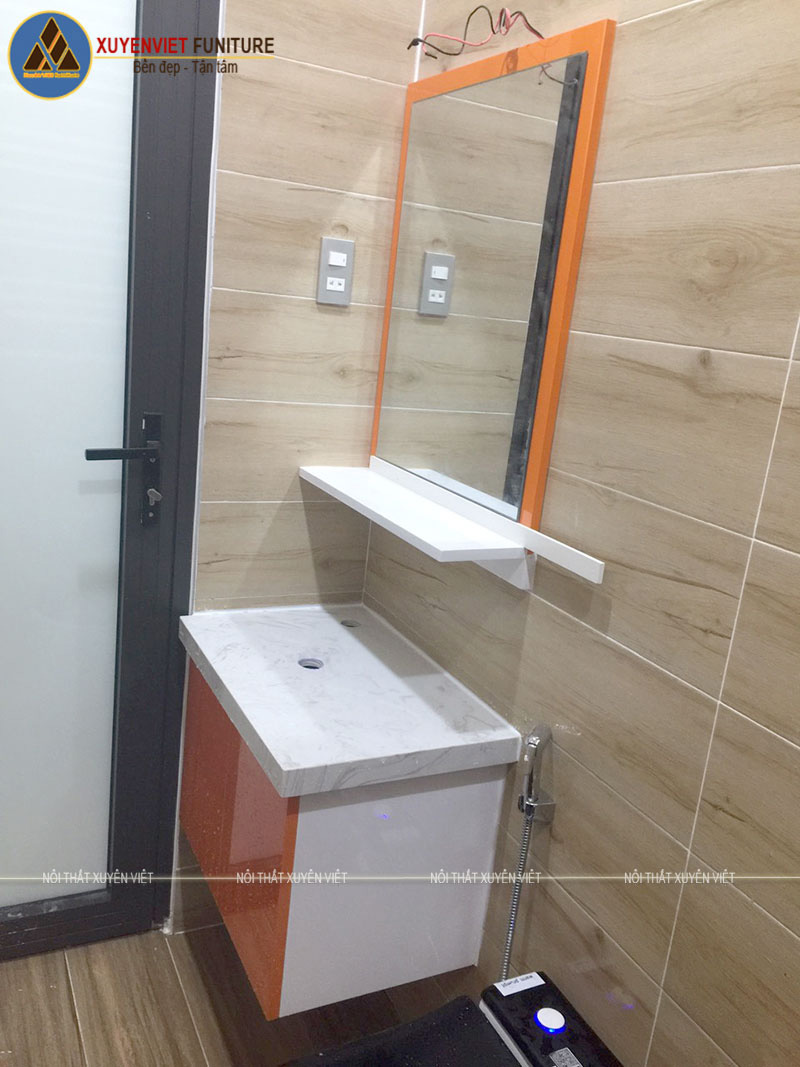 Bộ tủ lavabo treo tường mang tông màu cam nổi bật sau khi thi công xong nét hơn 3D khiến chị Hiền vô cùng hài lòng